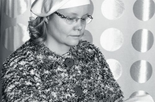 Black and white portrait of a caucasian adult woman in winter fashion clothing.