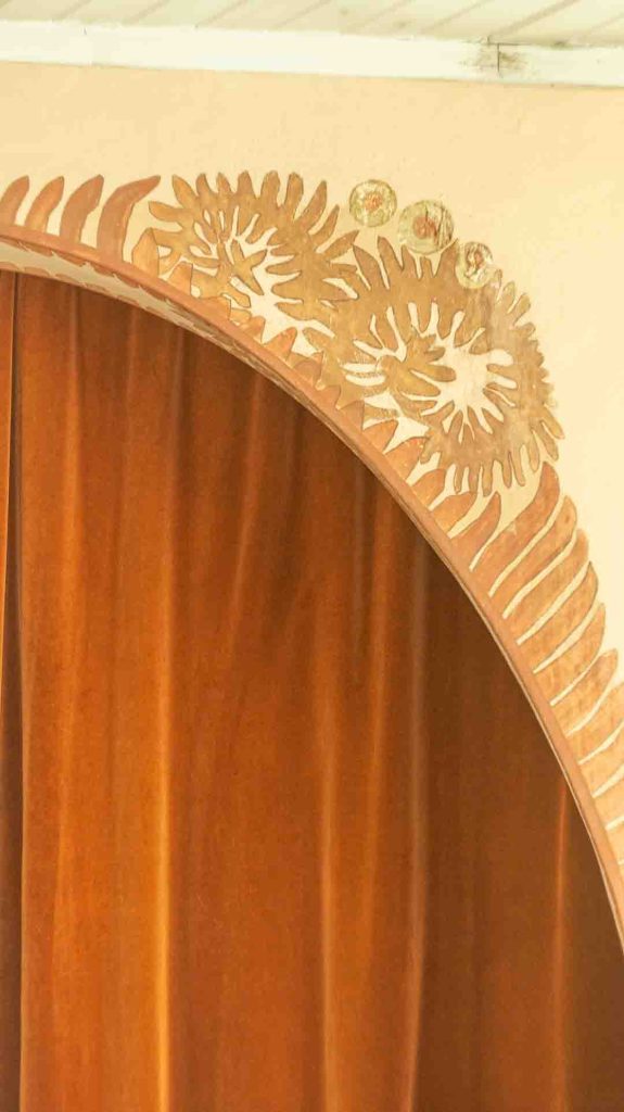 Lähikuva Imatran Valtionhotellin jugend-tyylisestä, valkoisesta, tyylitellystä kasviaiheisesta ornamentista holvikaaressa.