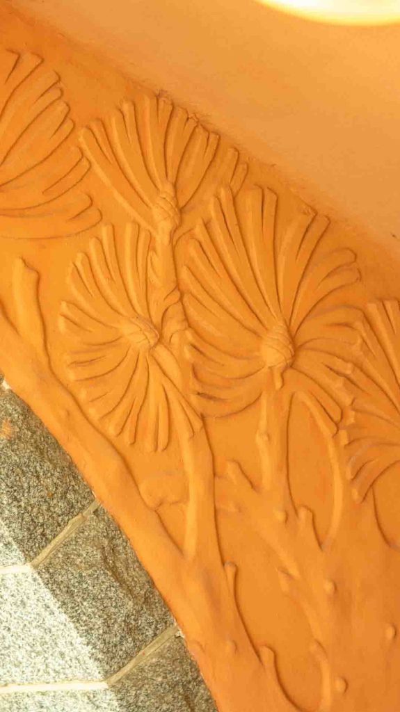 Lähikuva Imatran Valtionhotellin holvikaaren valkoisesta, jugend-tyylisestä, tyylitellystä kasviaiheisesta ornamentista.