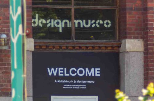 Helsingin Designmuseon tiilirakennuksen pääsisäänkäynti, WELCOME-kyltti toivottaa tervetulleeksi