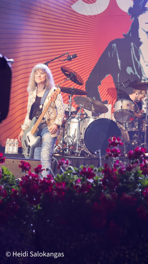 Suzi Quatro lavalla soittaa bassoa ja hymyilee yleisölle