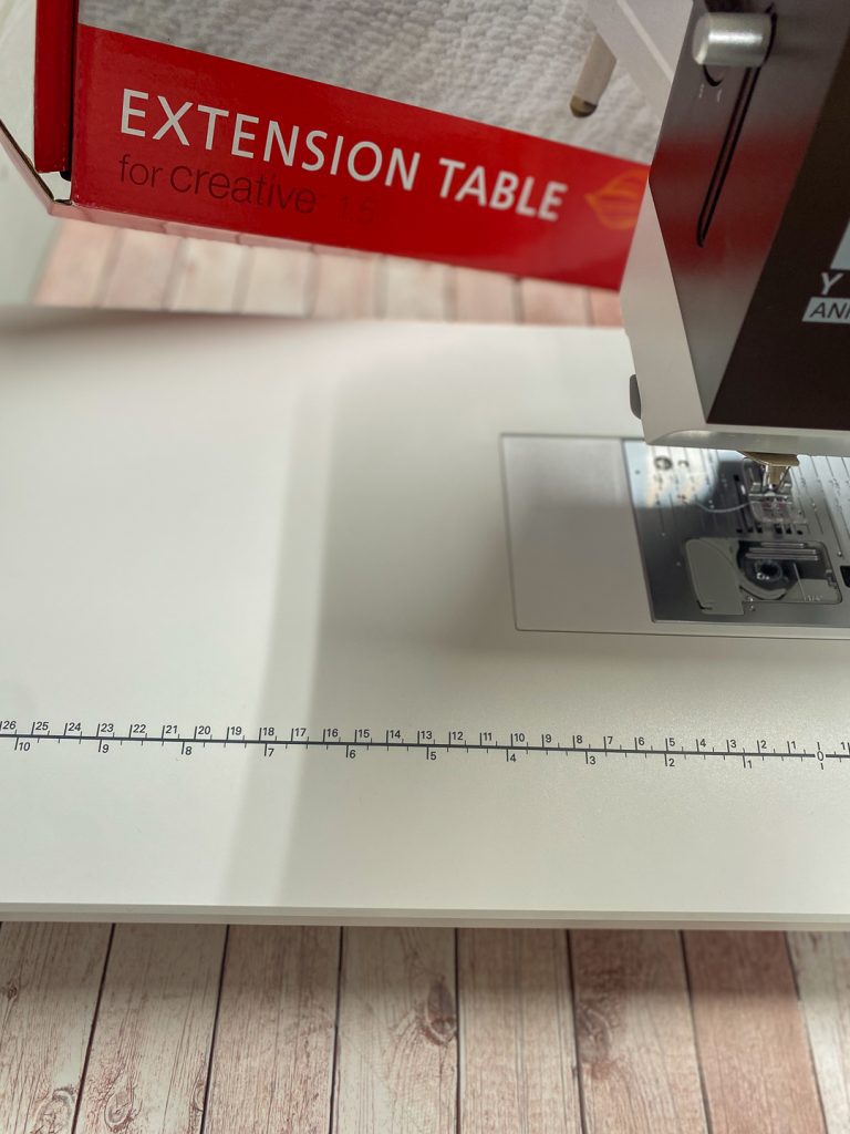 Ompelukone jatkopöydällä, koristeommel-liinan ompelu
