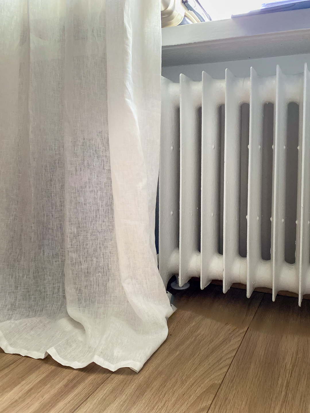 Valkoinen pellavaverho ja vanha patteri ikkunan alla – kodikas marraskuinen hetki