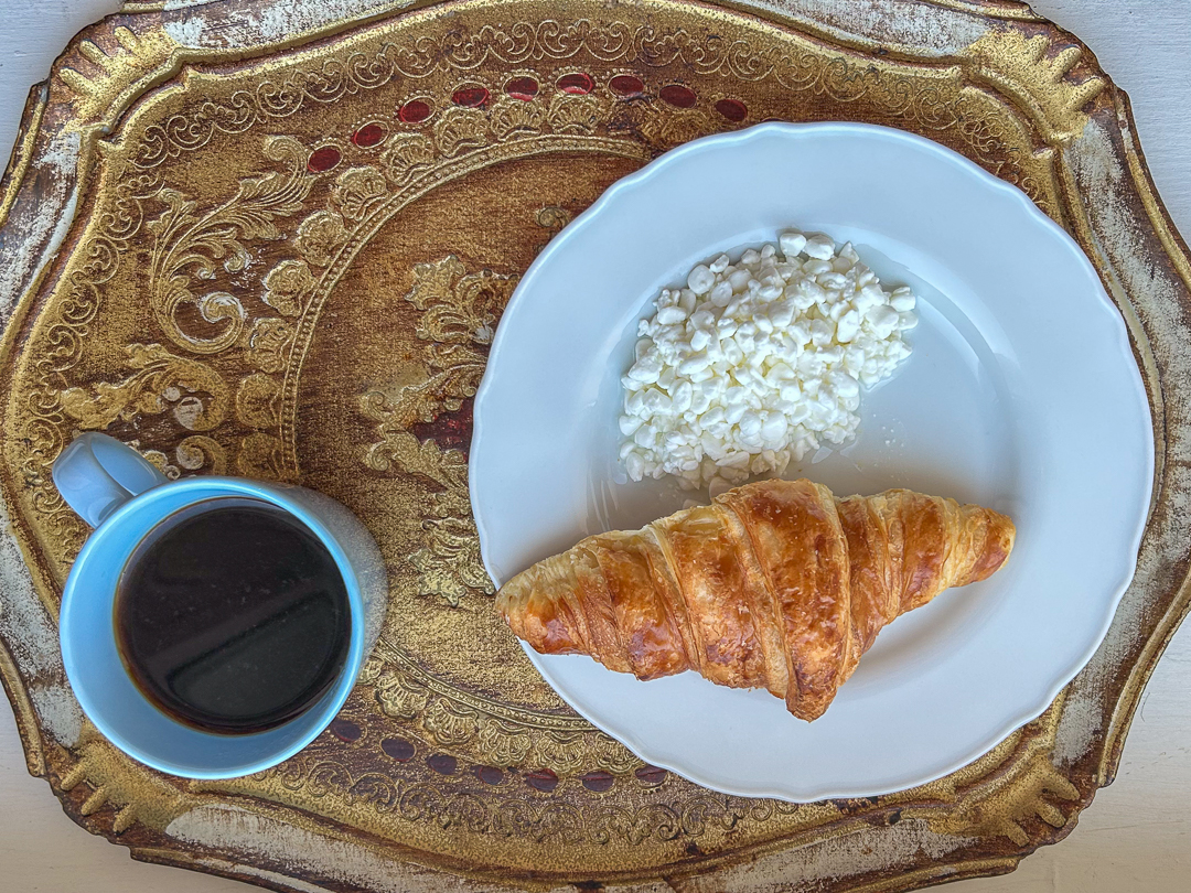 Aamukahvi, croissant ja raejuustoa rauhallisena hetkenä ennen työpäivää – pieni tauko, joka antaa tilaa ajatuksille ja käsillä tekemisen kaipuulle.