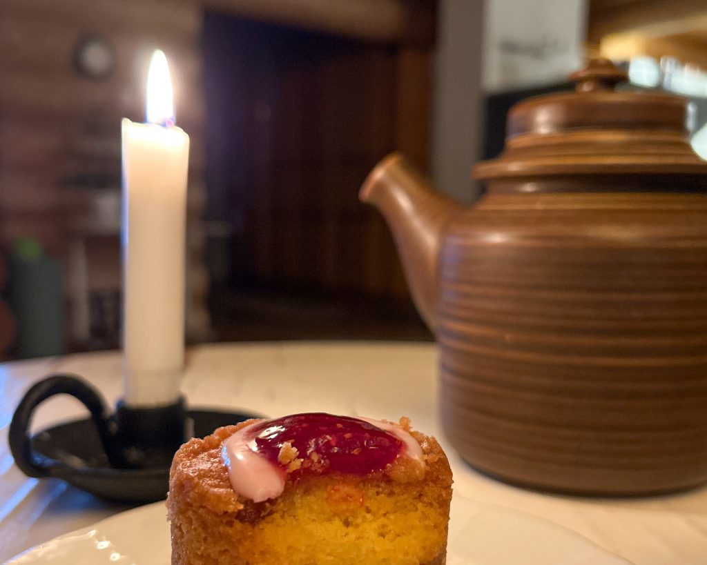 Tunnelmallinen lähikuva Runebergin tortusta ja kynttilästä