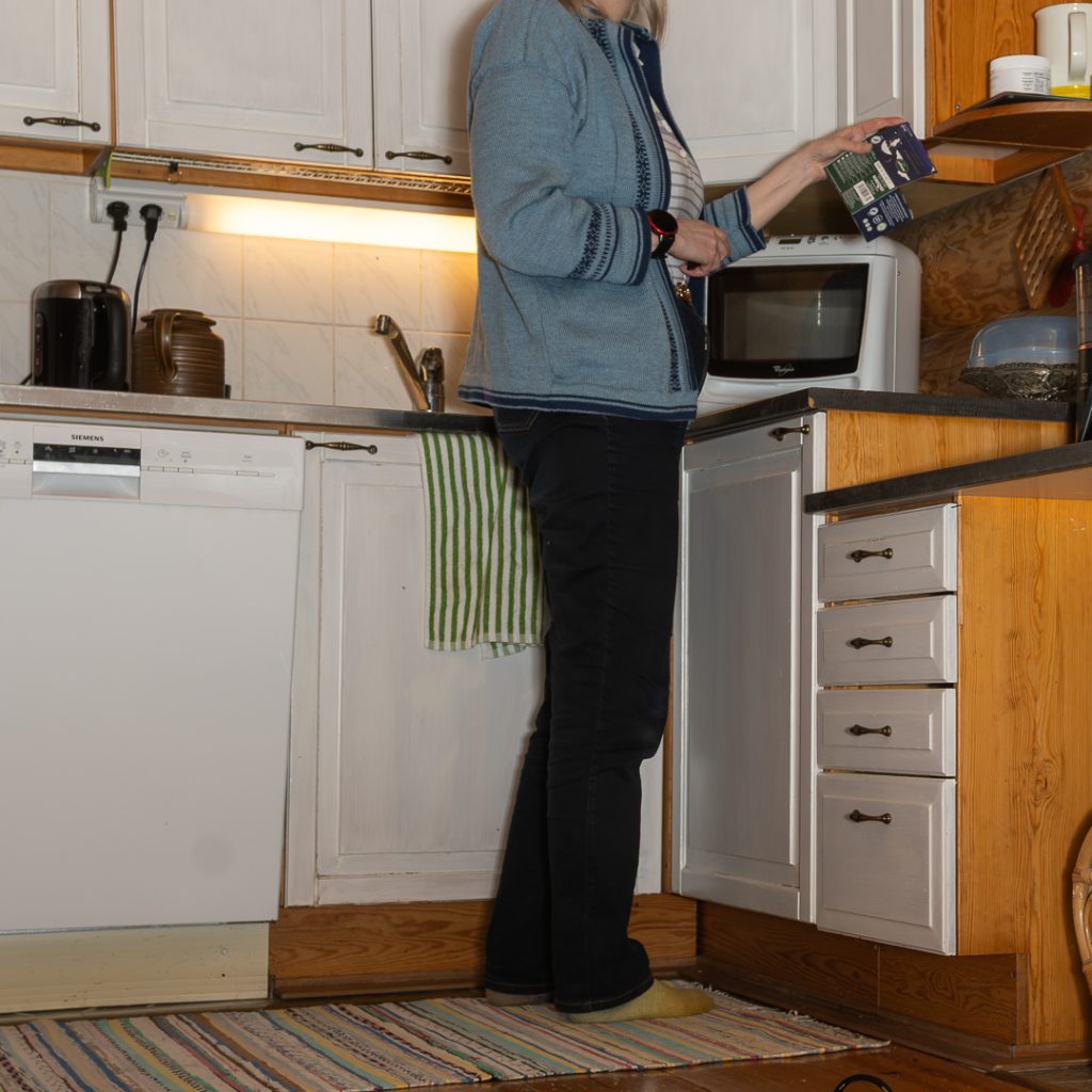 Sunnuntai-ilta kotikeittiössä – iltatee valmistuu ja päällä itse koneneulottu sininen jakku