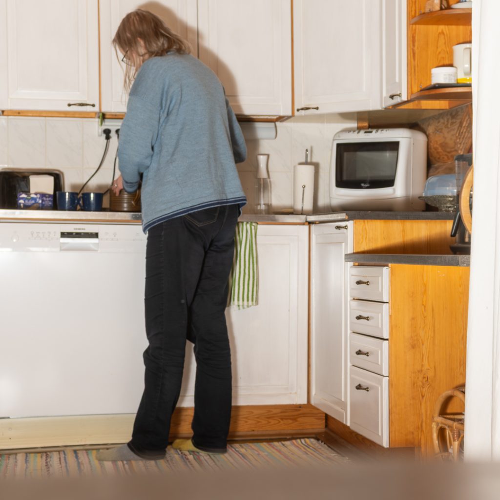 Sunnuntai-ilta keittiössä – sivutoiminen päätoimittaja harjoittelee salamavalon käyttöä, päällä itse koneneulottu sininen jakku