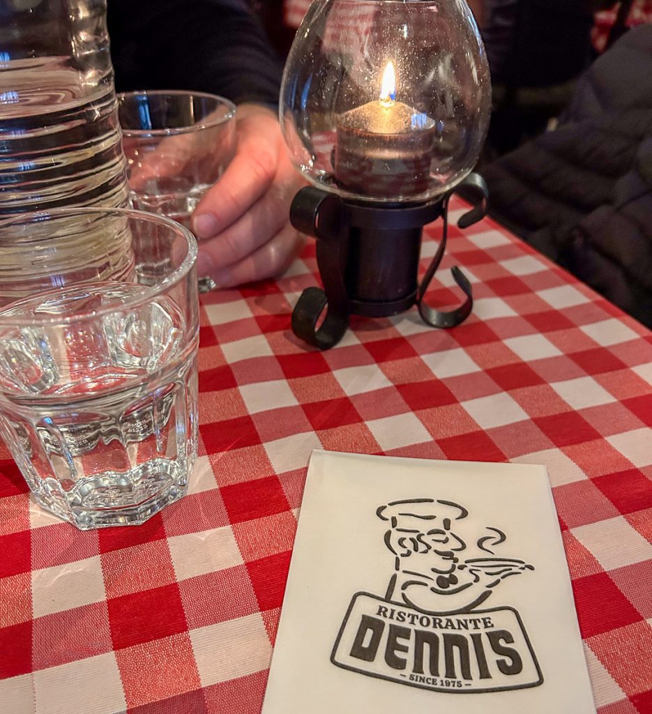 Tunnelmallinen ravintolapöytä Turussa: kynttilä, pizza ja lämmin valaistus hämärässä sisätilassa.
