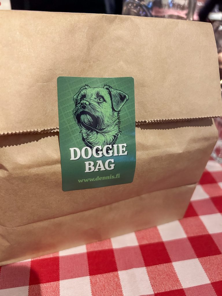Ravintolan doggie bag -paperikassi Turussa; pizzan jämät mukaan otettuna kynttilänvalossa.
